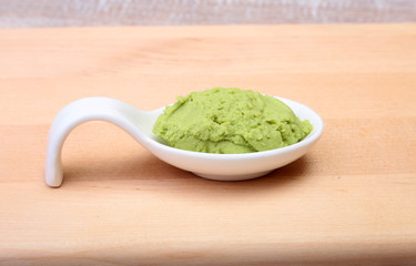 plate with Japanese wasabi sauce on wood background.