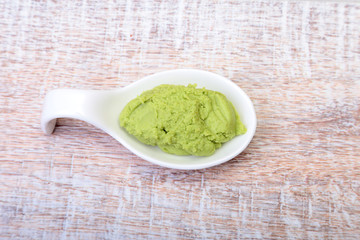 plate with Japanese wasabi sauce on wood background.