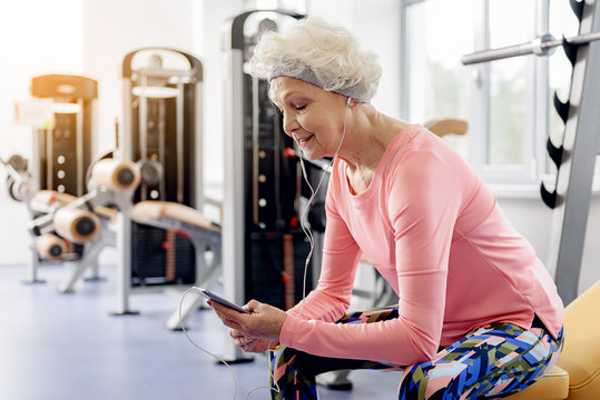 Smiling grandmother hearing song in fitness center
