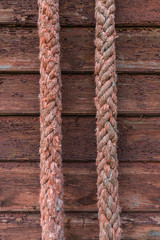 Old red rope on wooden texture