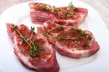 Raw pork chops, spices and rosemary on cutting board. Ready for cooking.