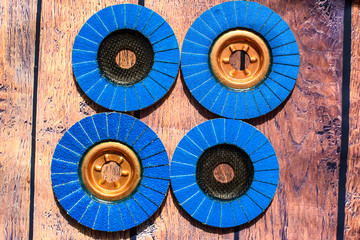 Grinder discs. A pile of color flap abrasive industrial disks on wood background texture. Great for grinding, metal finishing, sanding steel or inox. Grinder discs - professional equipment