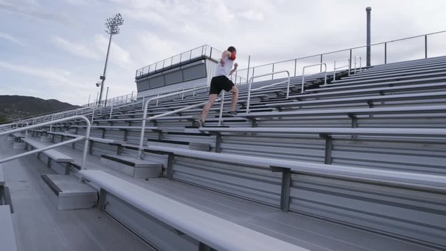 profile view of man doing sprints up bleachers