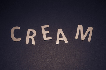 Cream written with colorful wooden letters on a black background