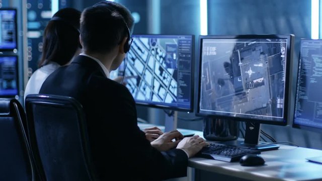  In Government Agency System Surveillance Center Employees Trace Criminal with Help of GPS. Room is Full of Displays with Various Data on Them. Shot on RED EPIC-W 8K Helium Cinema Camera.