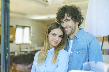 Obraz premium Daydreaming lovely couple. Shot of a thoughtful young couple gazing out of the window while standing at home.