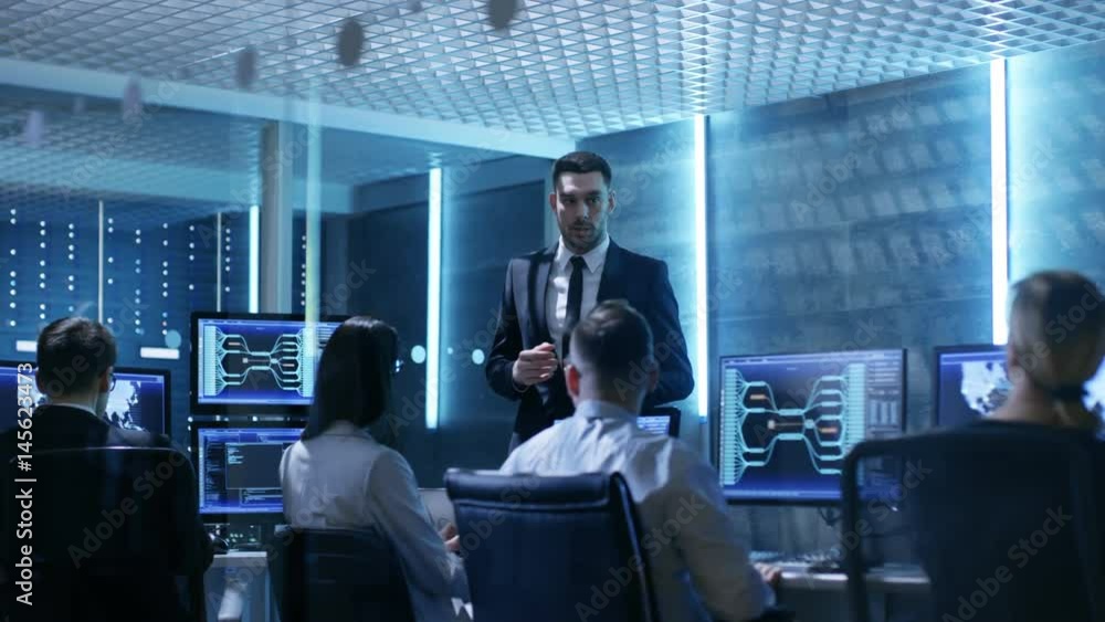 Leinwandbilder supervisor holds briefing for his employees in system control center full of monitors and servers. p