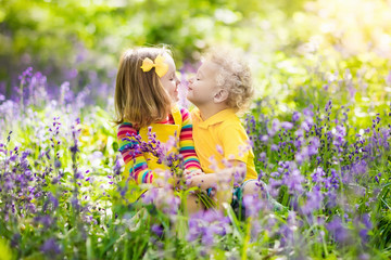 Kids playing in blooming garden with bluebell flowers