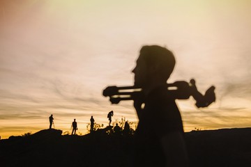 Silhouette of a man with a tripod against the background of a canyon