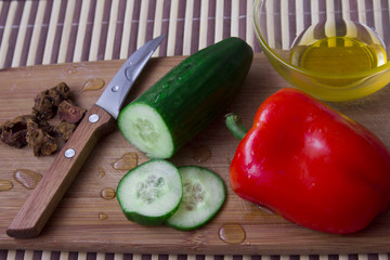 Vegetables with knife at the table. Cucumber with pepper 