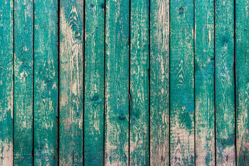 Fototapeta na wymiar Old turquoise wooden fence in the village, vintage background