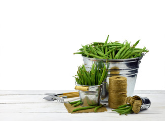 Green peas and garden tools isolated on a white background without a shadow.