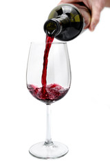 Red wine poured from a bottle in a elegant crystal goblet, isolated on white background.