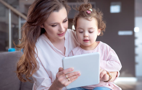 Pretty Mom Playing Tablet With A Daughter