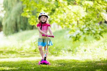 Little girl riding a colorful scooter