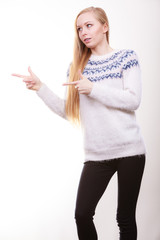 Teenage blonde woman pointing at copyspace