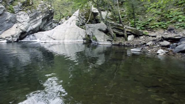 Small waterfall, rocks and poddle with reflection HD footage.