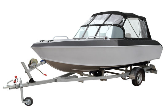 Motor boat with canvas top on a trailer for transportation.