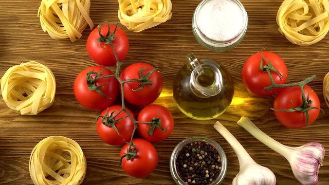 pasta, oil, tomatos and garlic on wooden background
