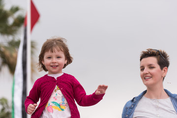 mother and cute little girl on the promenade by the sea