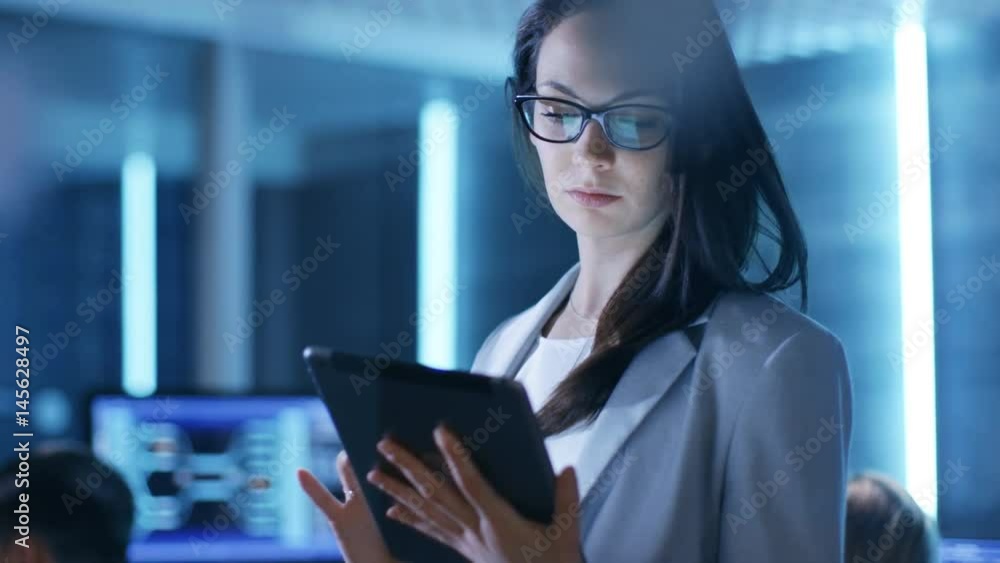 Aufkleber young female government employee uses tablet in system control center. in the background her coworke