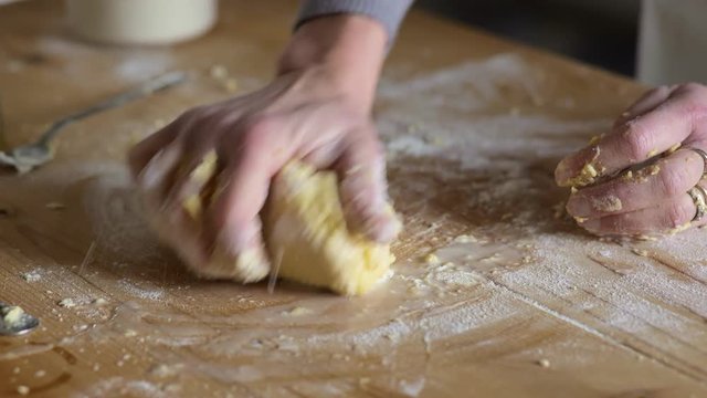 close up on Hands of woman putting flour on fresh dough and kneading