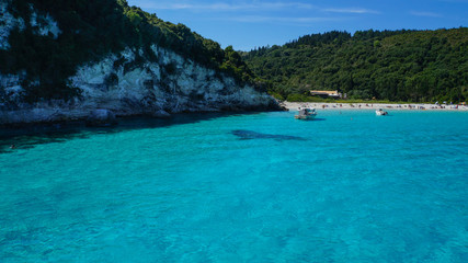 Turquoise water, ships and alga under water at a bay in greece