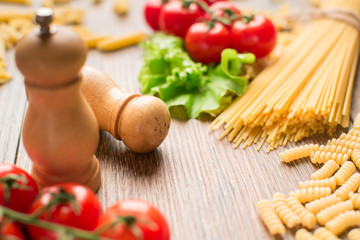 pasta with tomatoes and basil on wooden table