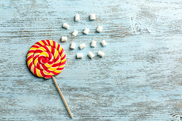 Composition with tasty colorful lollipop on wooden background