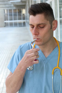 Careless doctor smoking a cigarette - Stock image