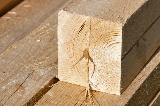 Pile of rectangular wooden beams in the construction site.