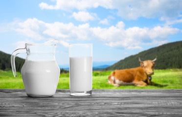 Milk in decanter and glass against the backdrop of mountain past