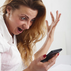 Fototapeta premium Desperate young businesswoman holding smartphone and shouting