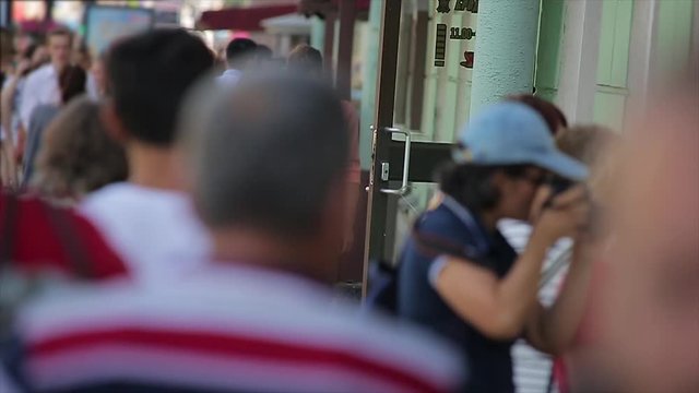 Young couple walk along the busy city street and look at their smartphones in slow motion