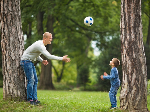 Cute little boy is enjoying playtime with his dad in a park