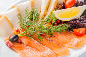 Salmon fillet pieces, sturgeon pieces served with lemon, black olives, herbs, cherry tomato and...