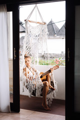 woman playing ukulele in hammock