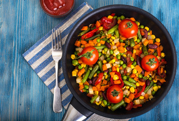 Mix of steamed vegetables on blue background
