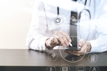 close up of smart medical doctor working with smart phone and stethoscope on dark wooden desk with virtual icon diagram