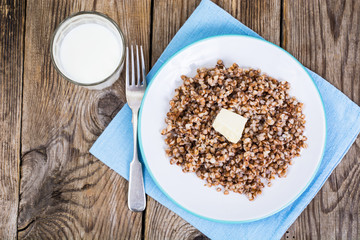 Glass with milk and boiled buckwheat porridge