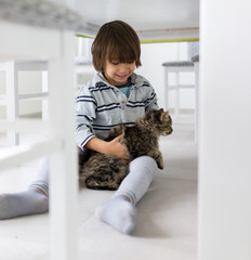 Happy kid at home with cat pet