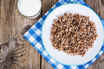 Glass with milk and boiled buckwheat porridge