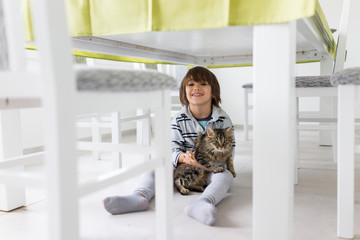 Fototapeta na wymiar Happy kid at home with cat pet