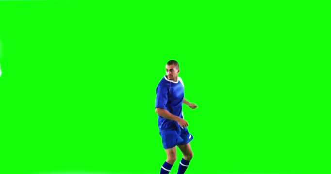 Athlete practicing soccer against green screen