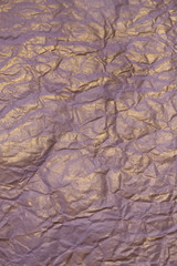 The texture of crumpled paper purple and gold