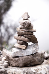 Fototapeta na wymiar pyramid shaped stacked stones on a hillside
