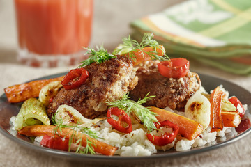 Cutlets with a garnish of rice and fried vegetables. Close-up, selective focus, toned in Photoshop.