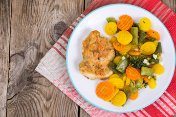 Chicken fillet grilled with vegetable mixt on wooden background