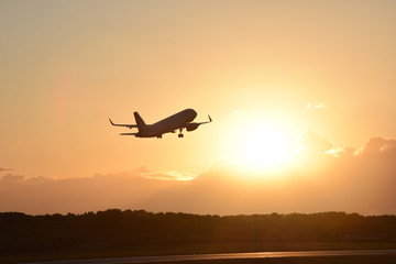 Plane taking off with sunset in background