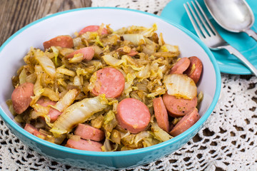 Sliced pork sausages with cabbage in ceramic bowl